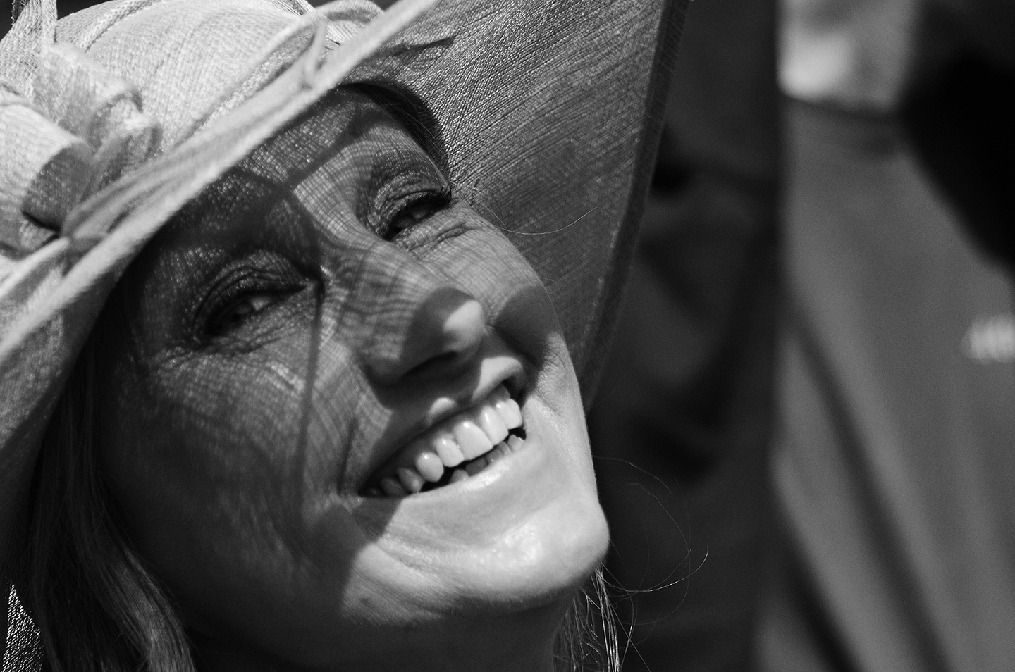 Portrait einer lachenden Frau mit Sonnenhut